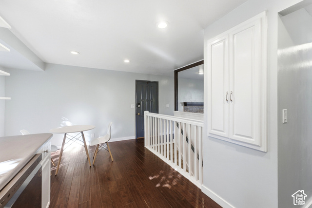 8746 Gladiator Way Sandy, UT 84094 - Photo 6 of 36 Hardwood-finish flooring, recessed lighting, white wood railing, built-in white cabinetry, and a dark paneled door