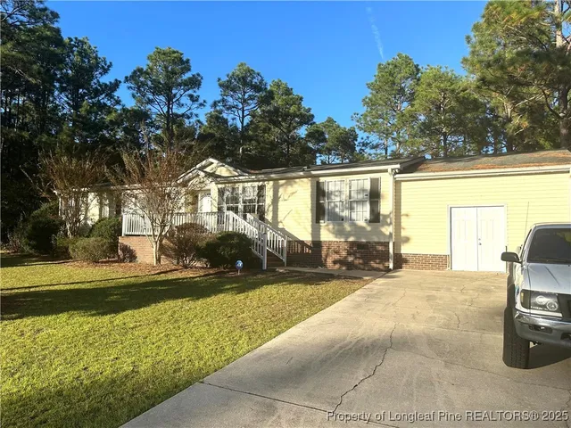 a view of a house with backyard and sitting area