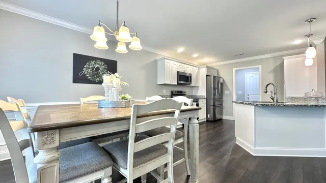 a kitchen with stainless steel appliances granite countertop a refrigerator a stove top oven a sink and dishwasher with wooden floor