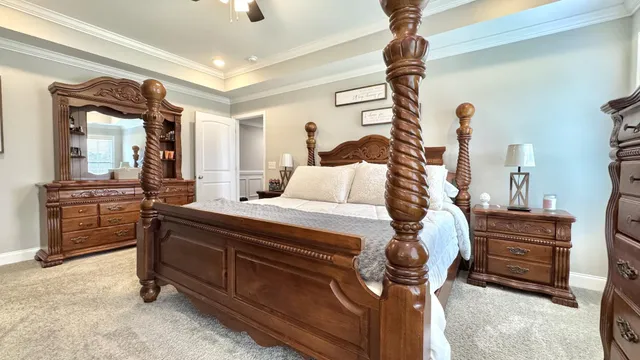 a bedroom with a bed and a chandelier with a flat tv screen