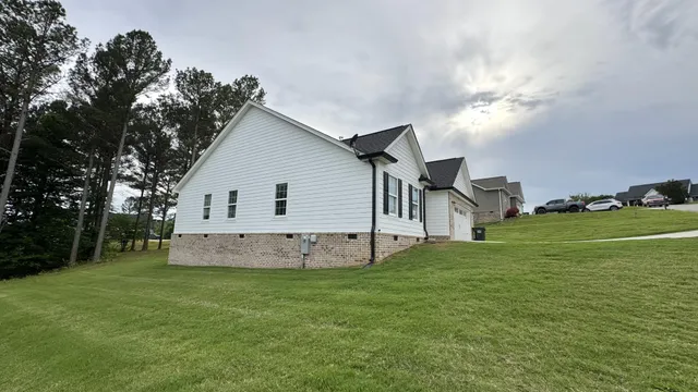 a view of a house with a big yard with large trees