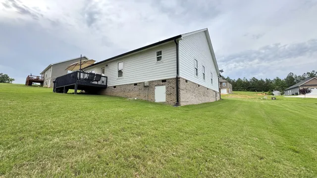 a view of a house with a big yard and large trees
