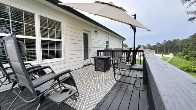 a view of deck with table and chairs with wooden floor and fence