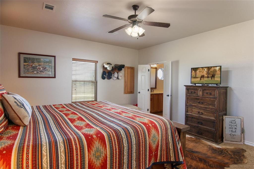 7158 Luella Road Sherman, TX 75090 - Photo 21 of 40 a bedroom with a bed and a chandelier