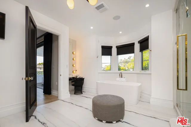 a kitchen with a sink dishwasher a stove and a dining table with wooden floor