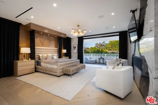 a bedroom with a large bed and a chandelier