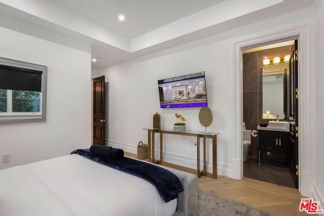 a spacious bedroom with a bed and a large mirror