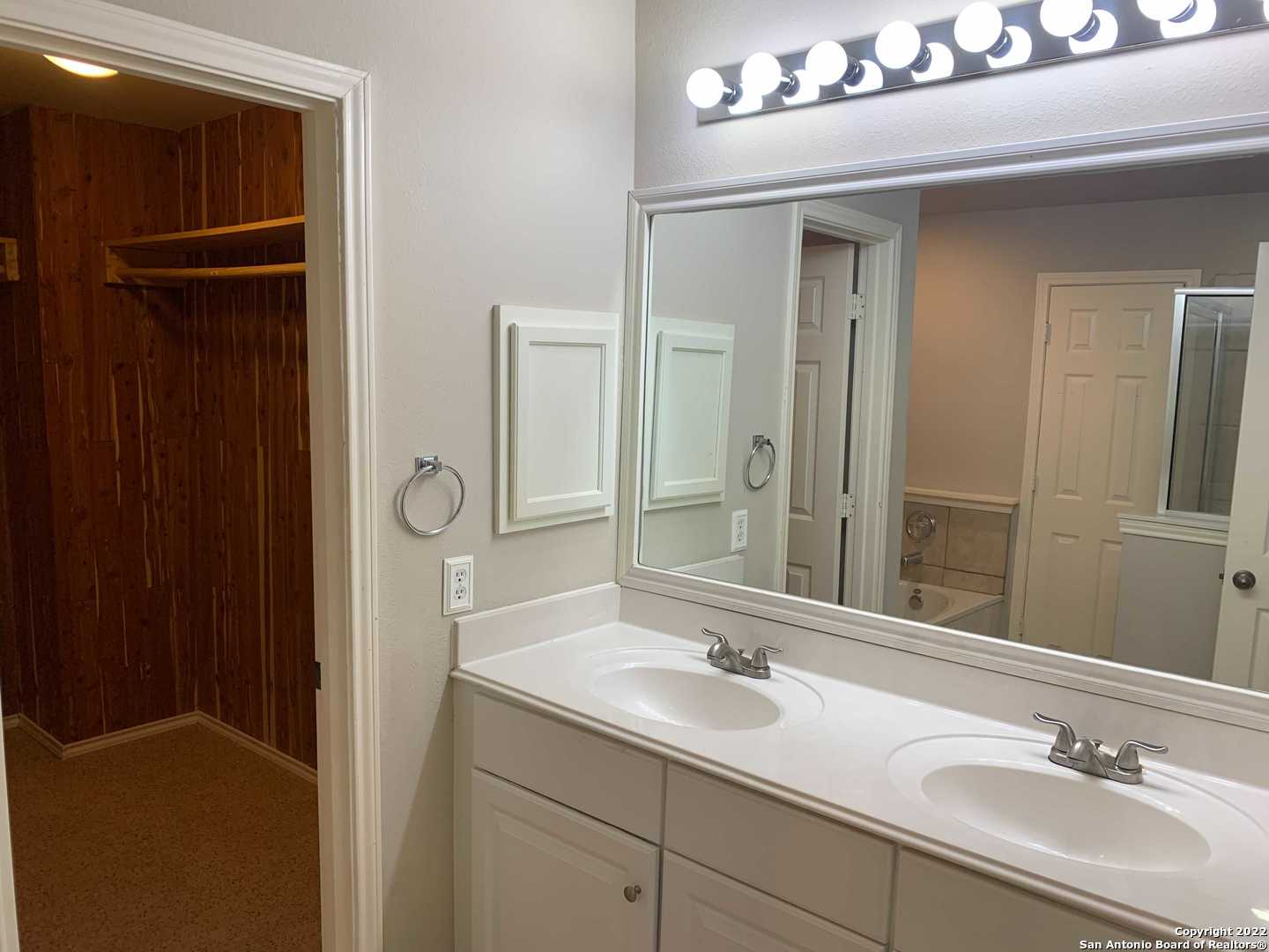522 Cattle Ranch Drive San Antonio, TX 78245 - Photo 16 of 24 a bathroom with a double vanity sink and mirror
