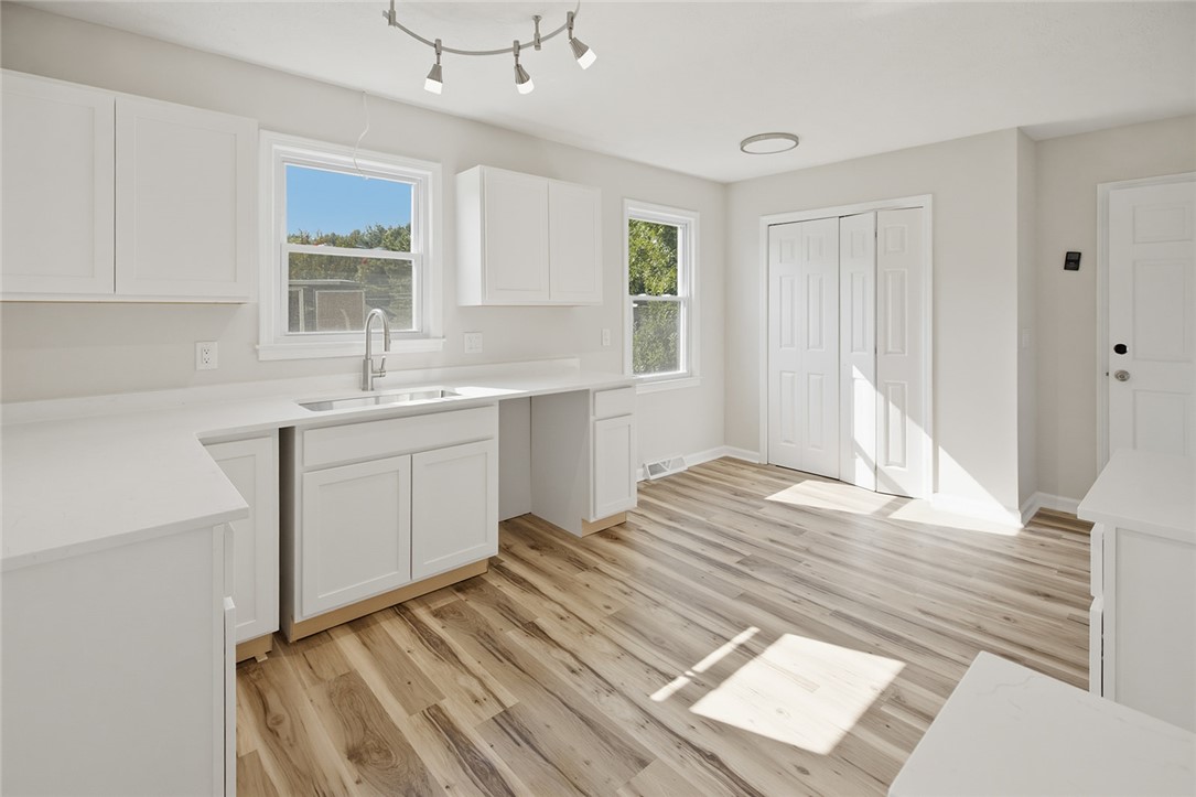 902 Cherokee Road Pelzer, SC 29669 - Photo 27 of 38 A well-lit kitchen with sleek white cabinetry and wood flooring awaits your personal touch.