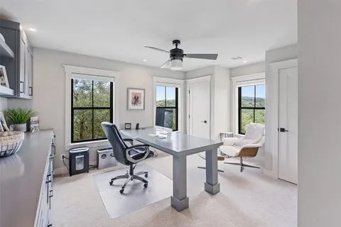 a view of a workspace with furniture and a window
