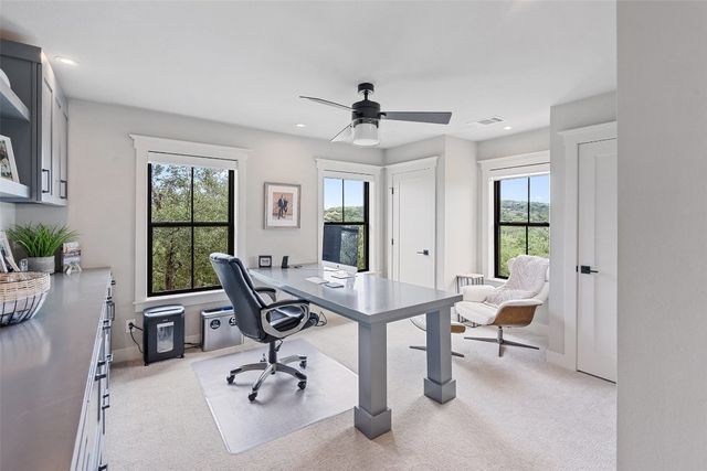 a view of a workspace with furniture and a window