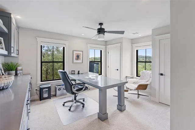 a view of a workspace with furniture and a window