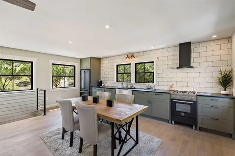 a kitchen with a stove a sink a dining table and chairs