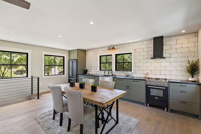 a kitchen with a stove a sink a dining table and chairs
