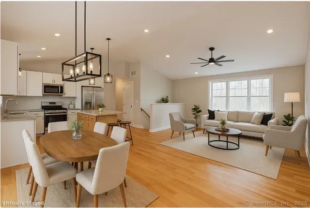 a living room with furniture kitchen view and a wooden floor