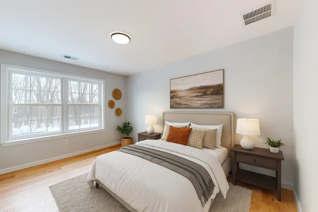 a bedroom with a bed and a large window