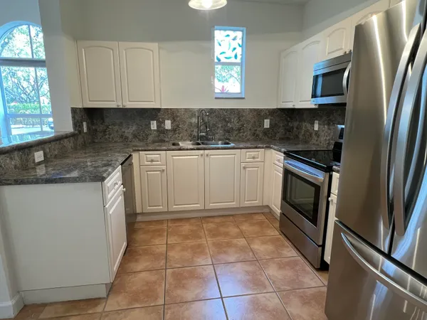 a kitchen with stainless steel appliances granite countertop a sink stove and microwave