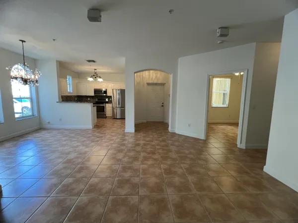 a view of a hallway with wooden floor and a living room