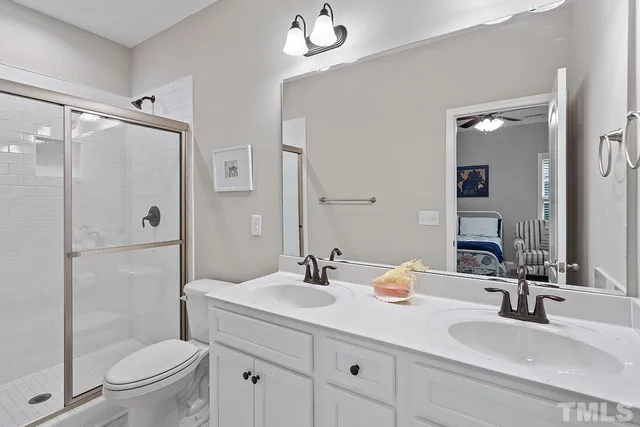 a bathroom with a double vanity sink toilet and shower