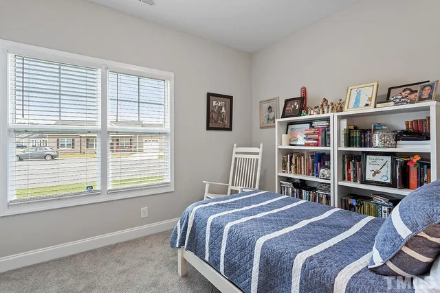 a bedroom with a bed and a book shelf