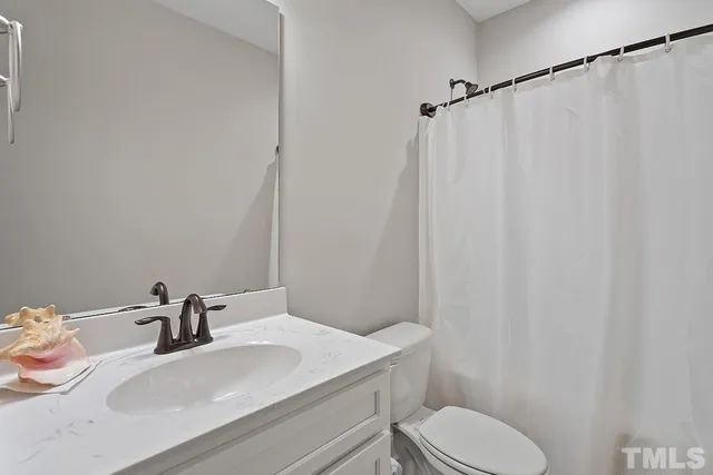 a bathroom with a sink toilet and a mirror