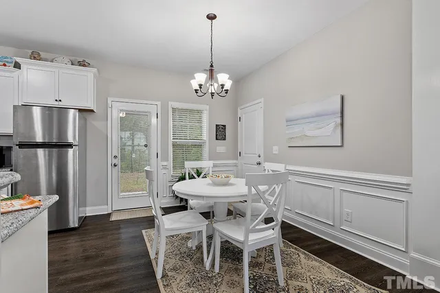 a dining room with furniture a chandelier and wooden floor