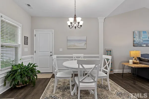 a dining room with furniture potted plants and wooden floor
