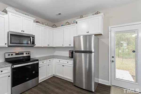 a kitchen with white cabinets and stainless steel appliances