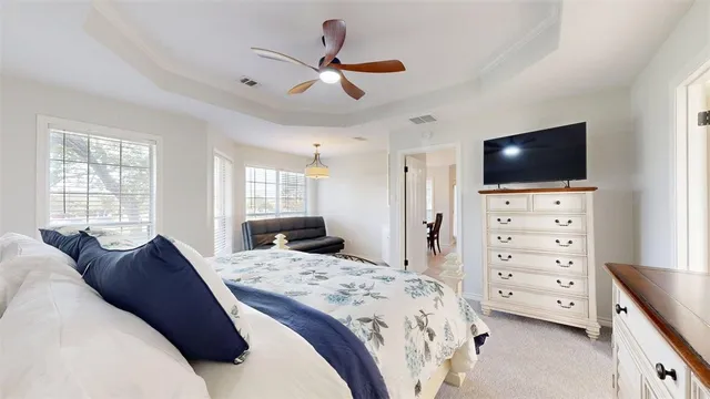 a spacious bedroom with a bed and a flat screen tv