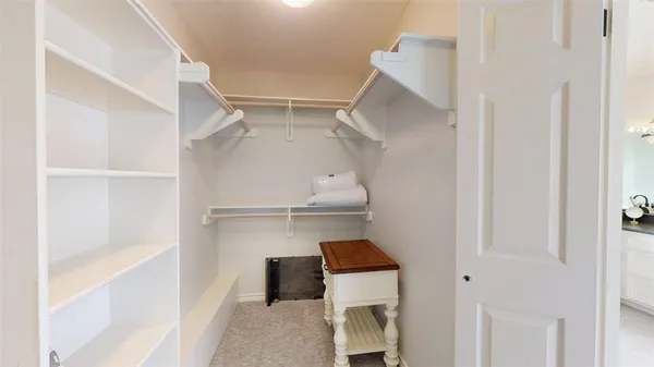 a view of walk in closet with empty racks