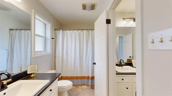 a bathroom with a sink a toilet and shower curtain