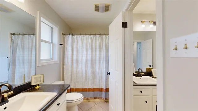 a bathroom with a sink a toilet and shower curtain