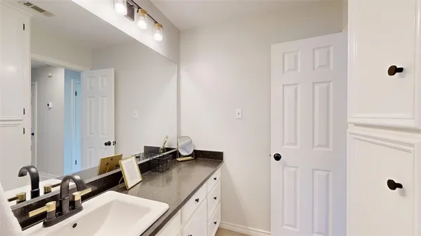 a bathroom with a granite countertop sink and a mirror