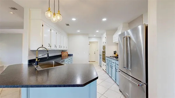 a kitchen with stainless steel appliances granite countertop a sink a stove and a refrigerator
