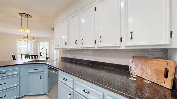 a kitchen with granite countertop white cabinets and white appliances