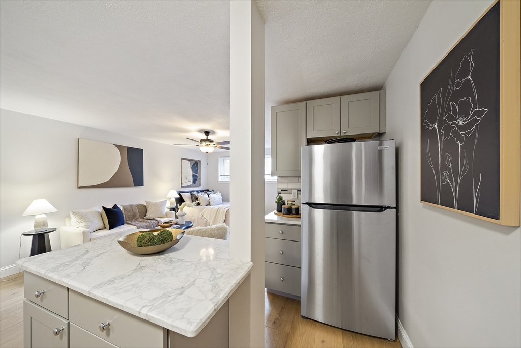 20 Radcliffe Road, Unit 112 Boston, MA 02134 - Photo 4 of 13 a kitchen with a refrigerator a sink dishwasher and a refrigerator with wooden floor