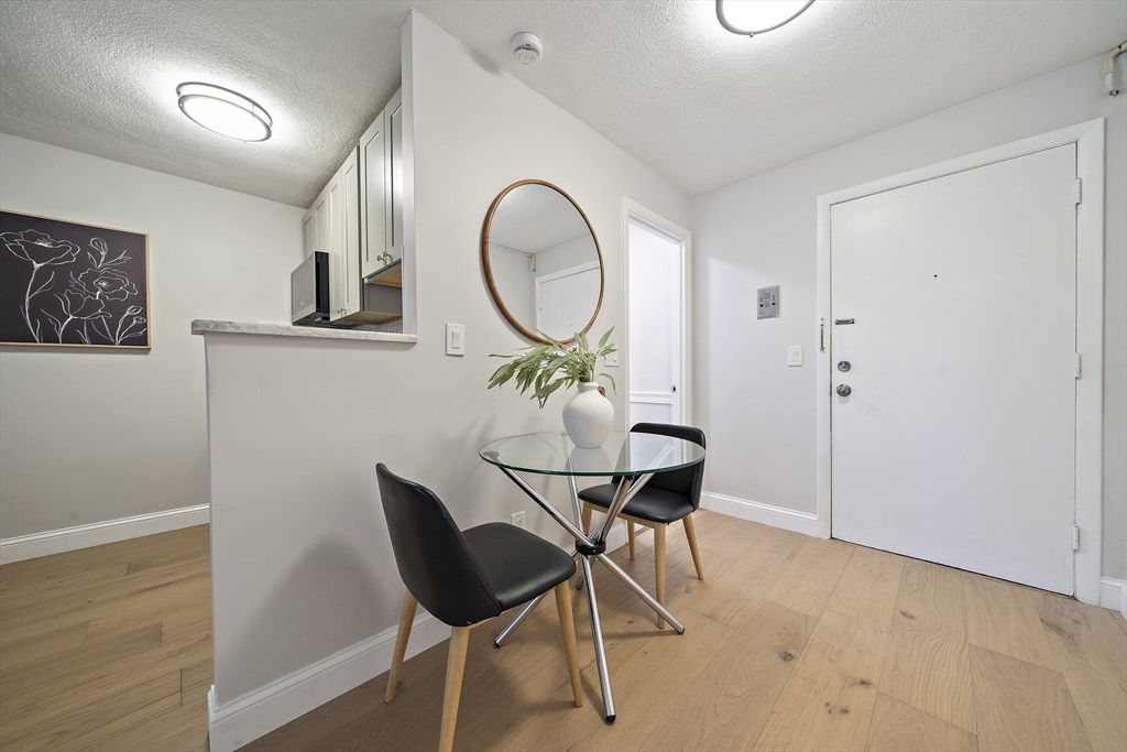 20 Radcliffe Road, Unit 112 Boston, MA 02134 - Photo 8 of 13 a dining room with furniture and a mirror
