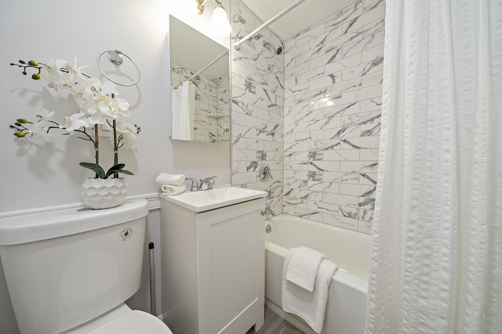 20 Radcliffe Road, Unit 112 Boston, MA 02134 - Photo 10 of 13 a bathroom with a sink a toilet and shower curtain
