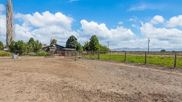 a backyard of a house with table and chairs with potted plants