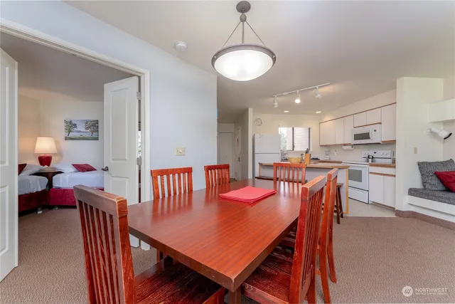 a view of a dining room and livingroom with furniture wooden floor a rug a chandelier