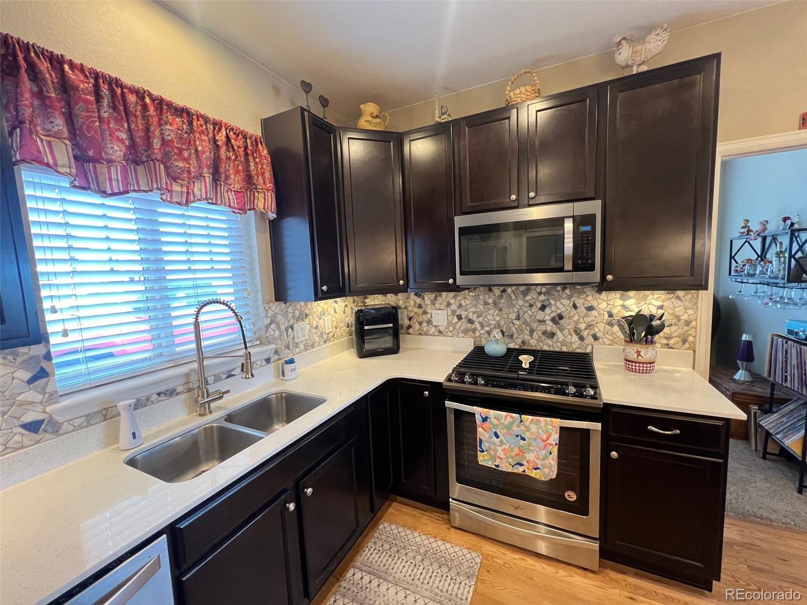2029 South Flanders Way, Unit B Aurora, CO 80013 - Photo 11 of 42 a kitchen with a sink stove and microwave