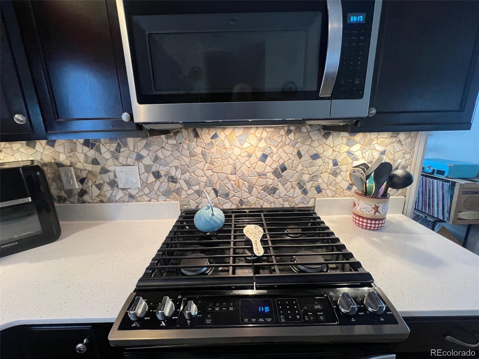 2029 South Flanders Way, Unit B Aurora, CO 80013 - Photo 12 of 42 a stove top oven sitting inside of a kitchen