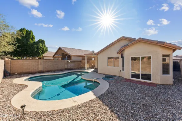 a view of a house with a backyard and swimming pool