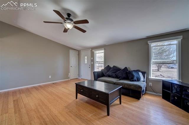 5860 Curtis Road Peyton, CO 80831 - Photo 8 of 28 Living area with light wood-type flooring, lofted ceiling, baseboards, and ceiling fan