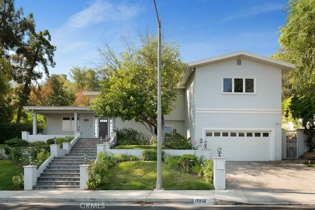 a view of a house with a small yard and potted plants