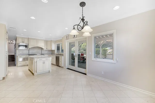 a kitchen with white cabinets and window