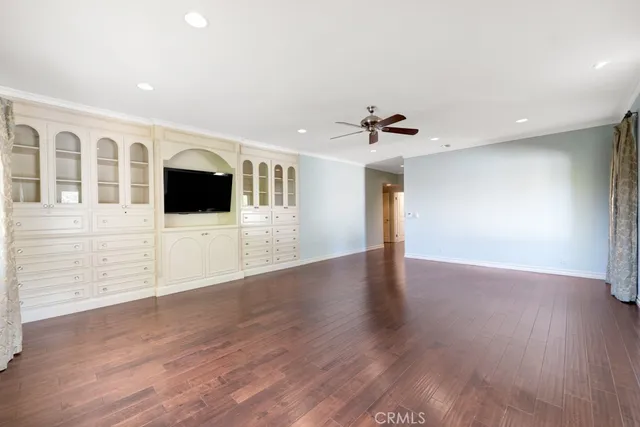 a view of a livingroom with wooden floor and a ceiling fan