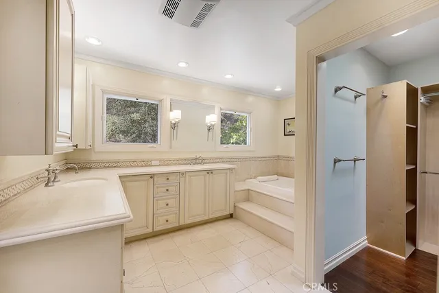 a bathroom with a sink a vanity a mirror and a bathtub
