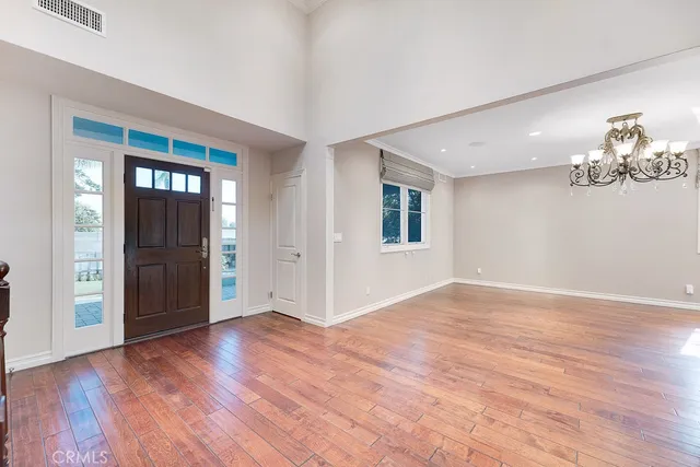 a view of an empty room with window and wooden floor