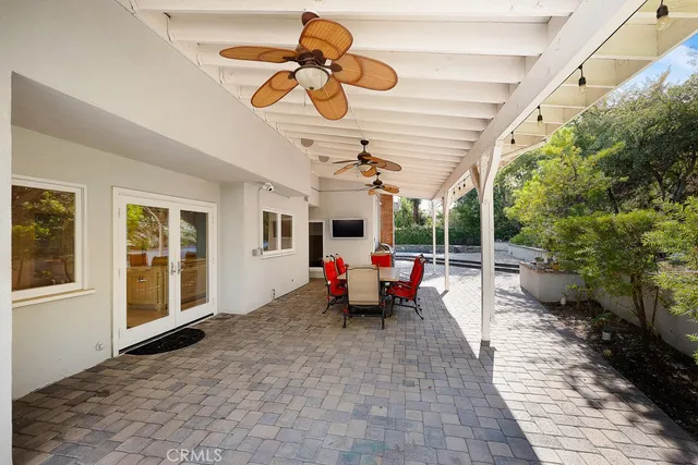 a view of a patio with table and chairs potted plants with floor to ceiling window